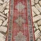 1970s red vintage turkish runner rug with geometric design, hand-knotted weave and low pile.