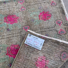 Close-up of the brown vintage turkish runner rug showing floral details, hand-knotted weave, wool and cotton and low pile.