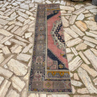 Pink 2' x 8' vintage turkish runner rug in wool and cotton, shown on the floor.