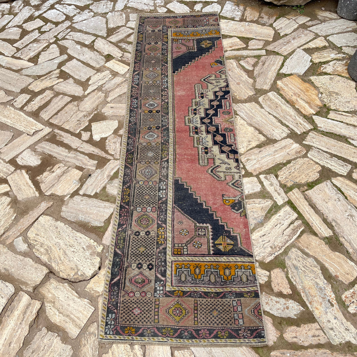 Pink 2' x 8' vintage turkish runner rug in wool and cotton, shown on the floor.