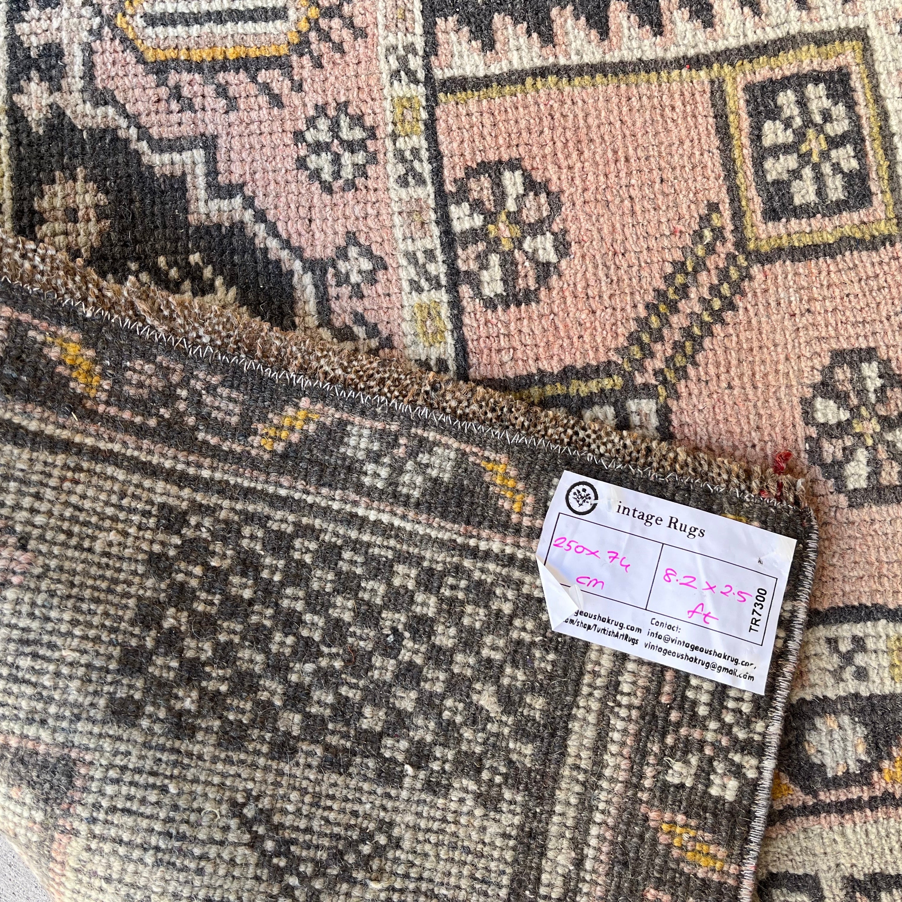 Close-up of the pink vintage turkish runner rug showing traditional details, hand-knotted weave, wool and cotton and low pile.
