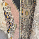 Pink 2' x 8' vintage turkish runner rug in wool and cotton, shown on the floor.