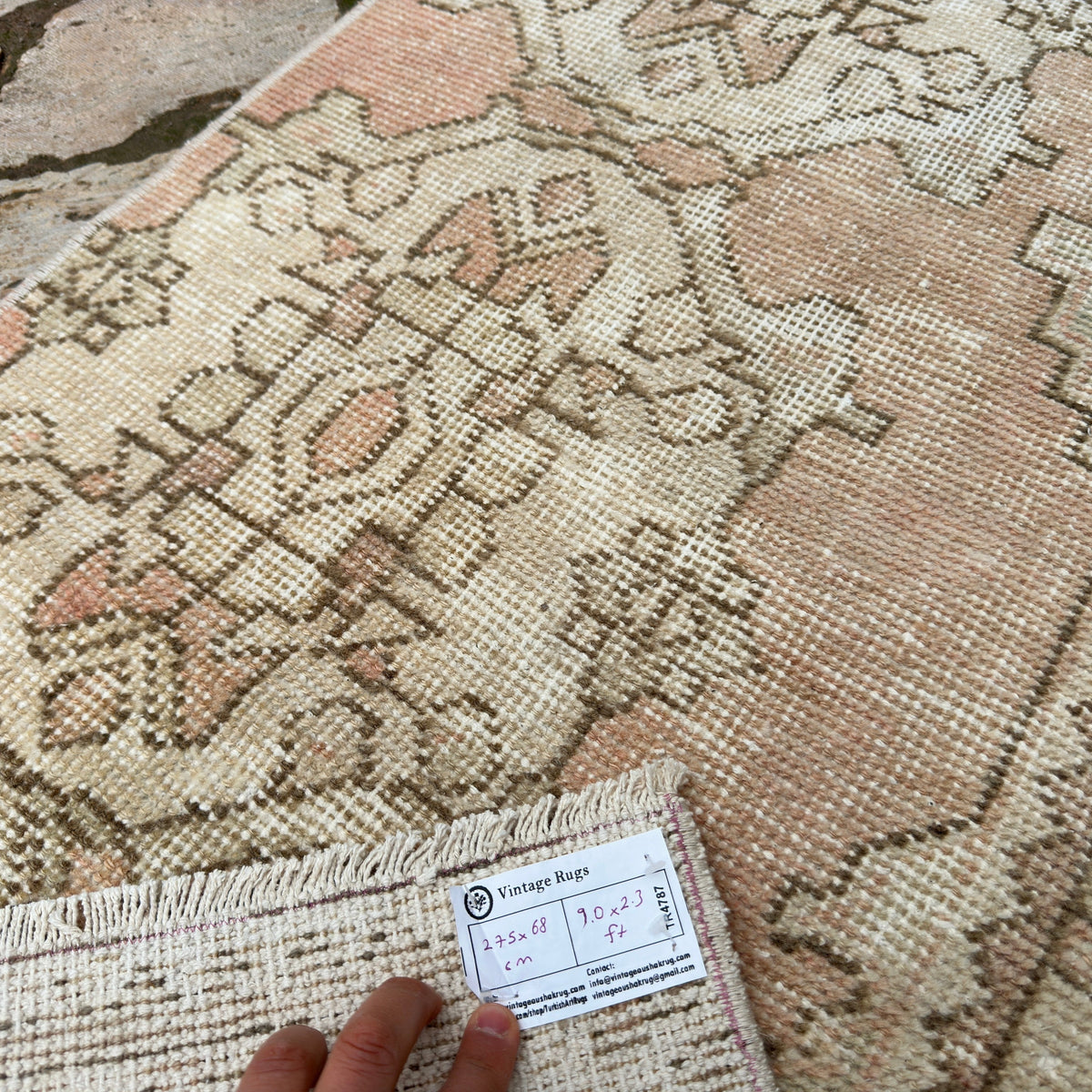Close-up of the pale red vintage turkish runner rug showing traditional details, hand-knotted weave, wool and cotton and low pile.
