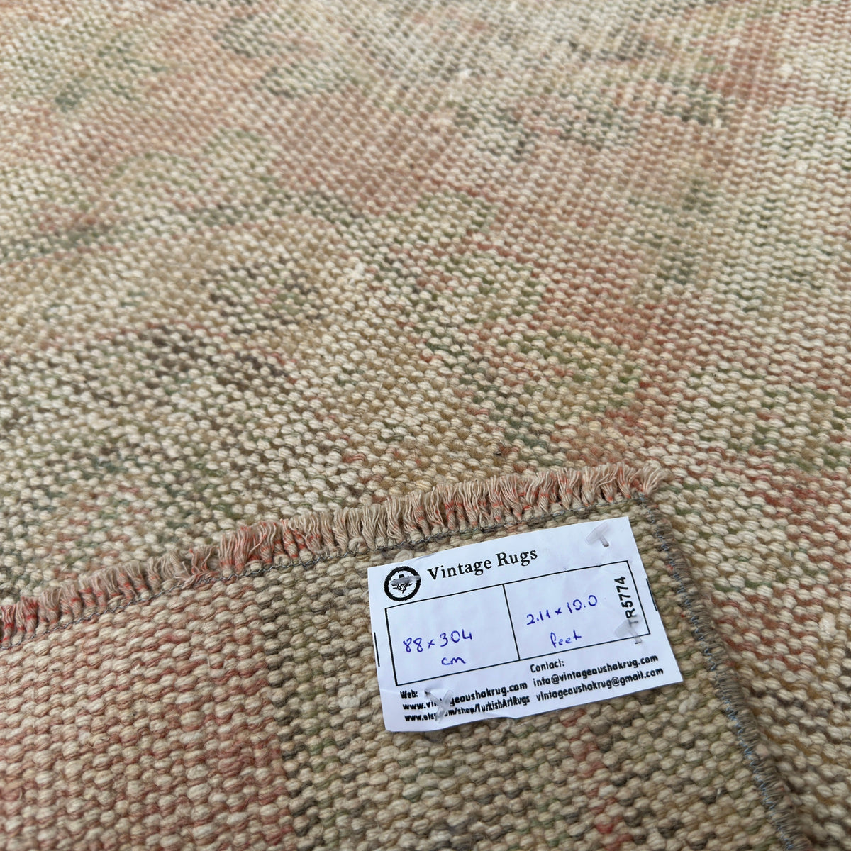 Close-up of the pale pink vintage turkish runner rug showing traditional details, hand-knotted weave, wool and cotton and low pile.