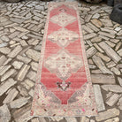 Pale Red 3' x 10' vintage turkish runner rug in wool and cotton, shown on the floor.