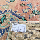 Close-up of the pale green vintage turkish runner rug showing floral details, hand-knotted weave, wool and cotton and low pile.