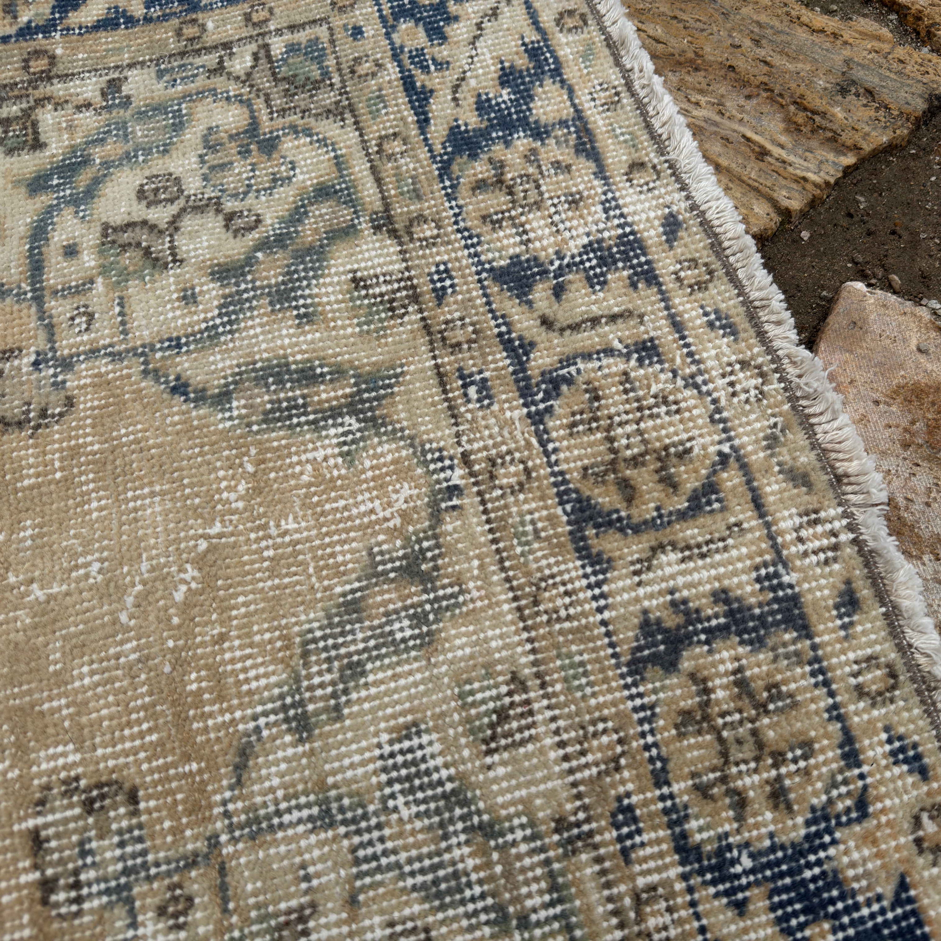 Close-up of the pale yellow vintage turkish runner rug showing medallion details, hand-knotted weave, wool and cotton and low pile.