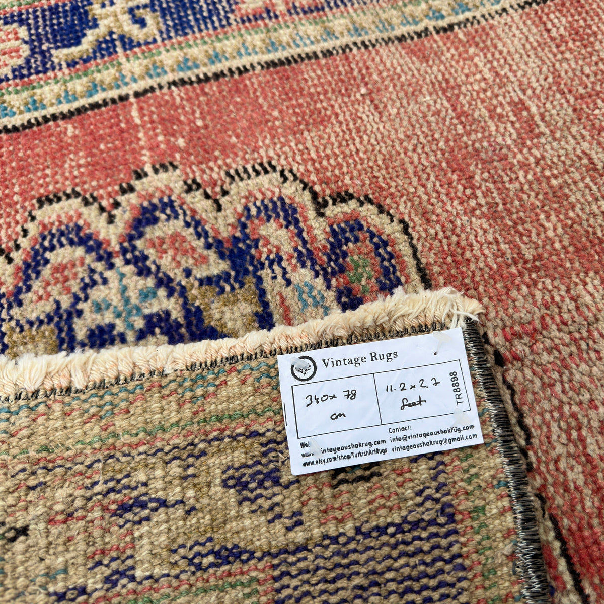 Close-up of the red vintage turkish runner rug showing traditional details, hand-knotted weave, wool and cotton and low pile.