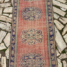 1970s red vintage turkish runner rug with traditional design, hand-knotted weave and low pile.