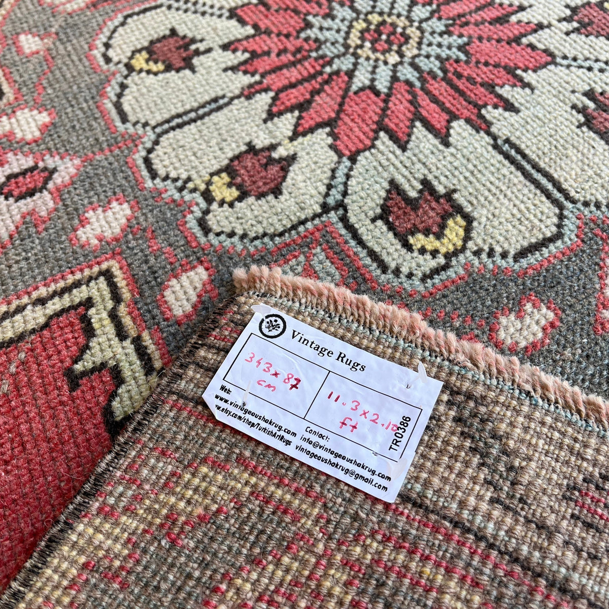 Close-up of the red vintage turkish runner rug showing traditional details, hand-knotted weave, wool and cotton and low pile.