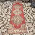 Red 3' x 11' vintage turkish runner rug in wool and cotton, shown on the floor.