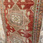 Close-up of the red vintage turkish runner rug showing traditional details, hand-knotted weave, wool and cotton and low pile.