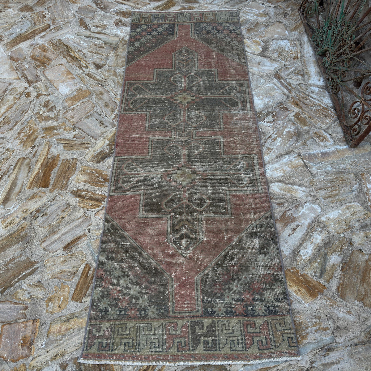 Close-up of the pink vintage turkish runner rug showing geometric details, hand-knotted weave, wool and cotton and low pile.