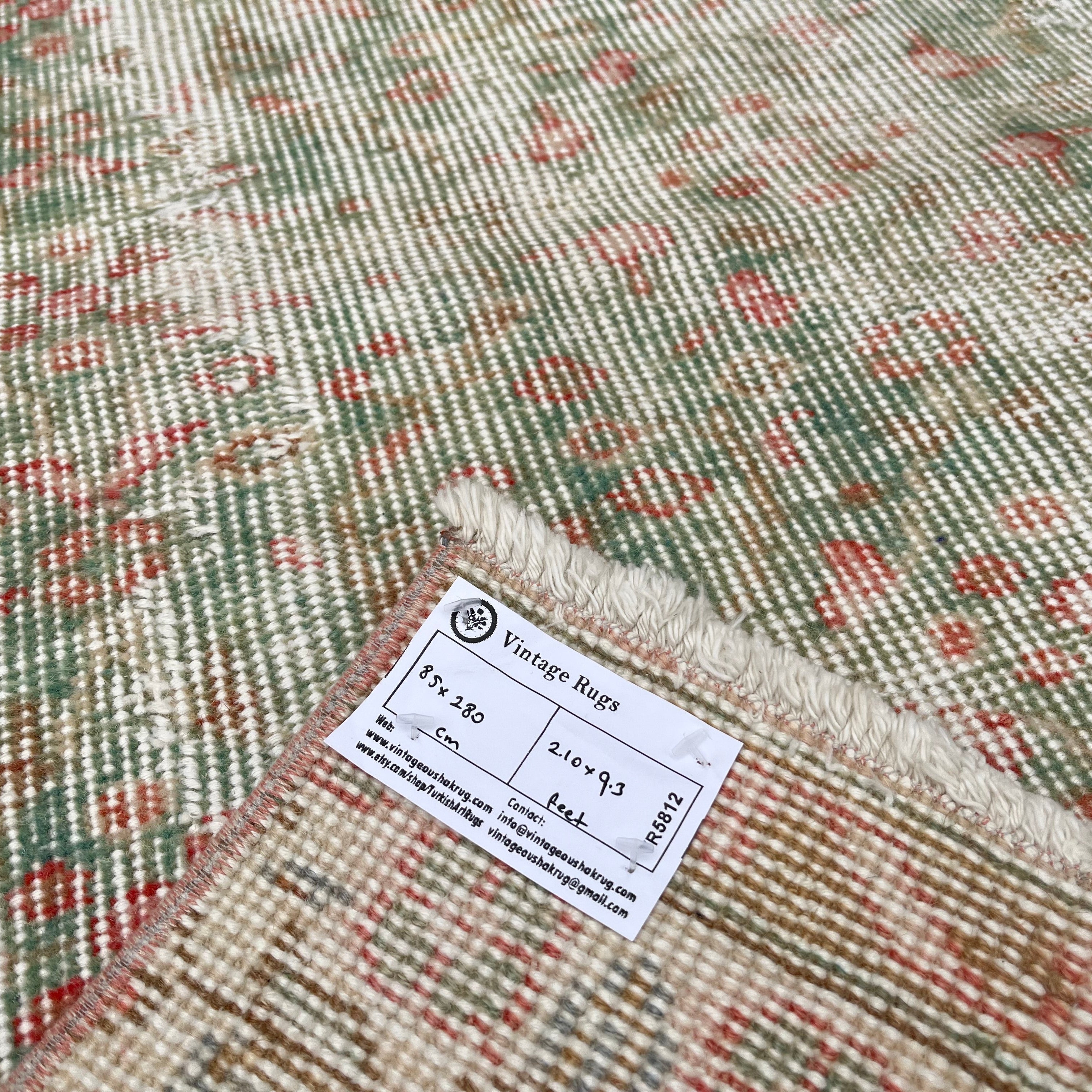 Close-up of the green vintage turkish runner rug showing floral details, hand-knotted weave, wool and cotton and low pile.