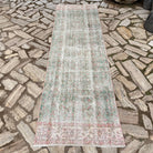Green 3' x 9' vintage turkish runner rug in wool and cotton, shown on the floor.