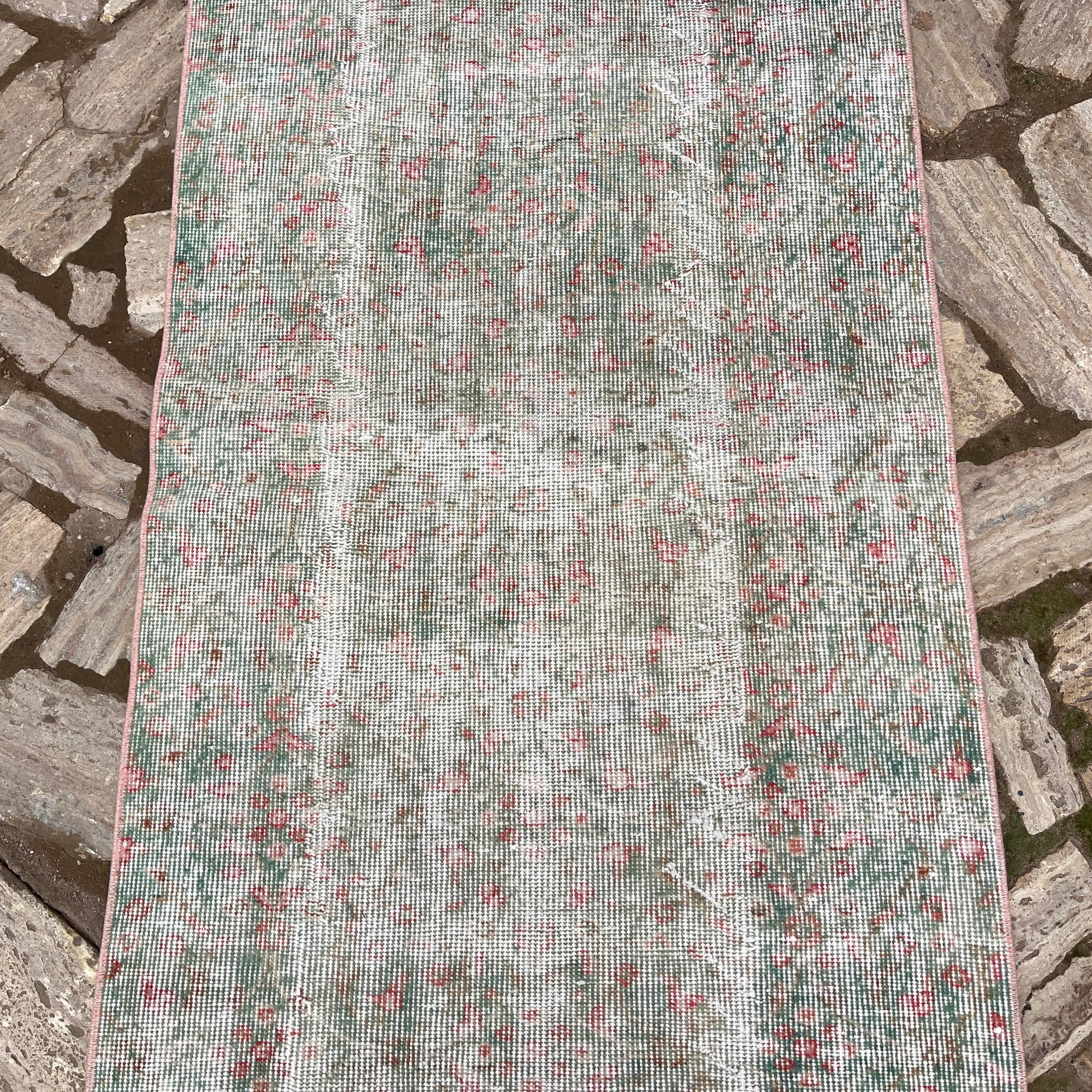 1970s green vintage turkish runner rug with floral design, hand-knotted weave and low pile.