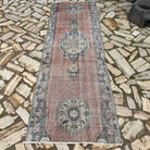 Red 3' x 9' vintage turkish runner rug in wool and cotton, shown on the floor.