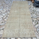 Brown 4' x 11' vintage turkish runner rug in wool and cotton, shown on the floor.