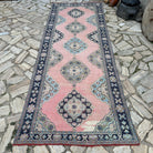 Pink 4' x 11' vintage turkish runner rug in wool and cotton, shown on the floor.