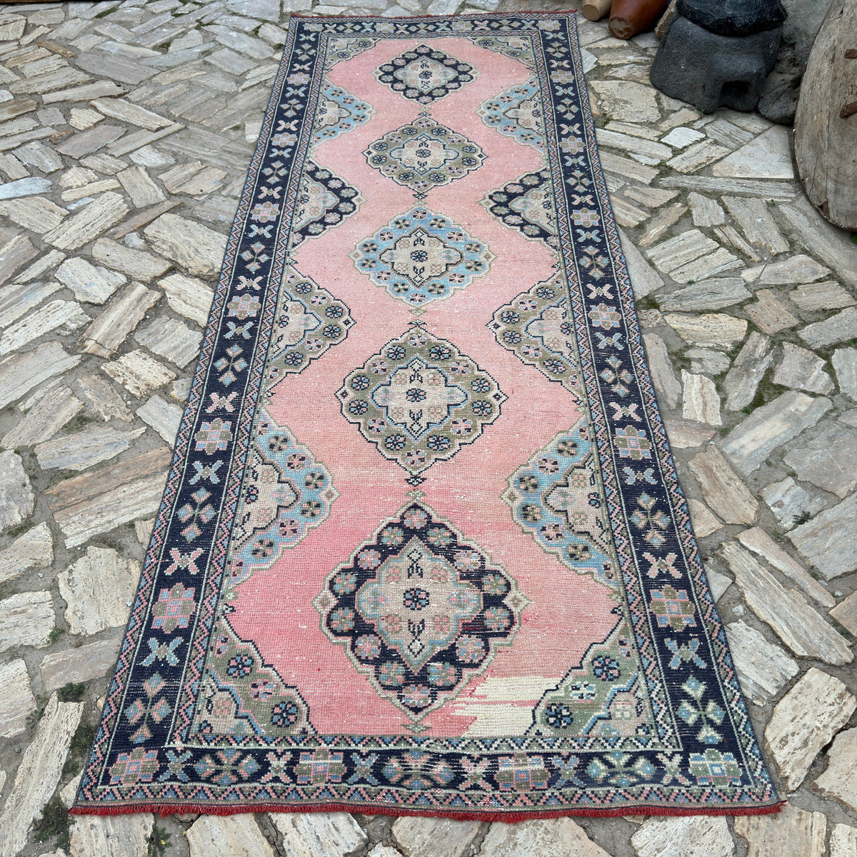 Pink 4' x 11' vintage turkish runner rug in wool and cotton, shown on the floor.