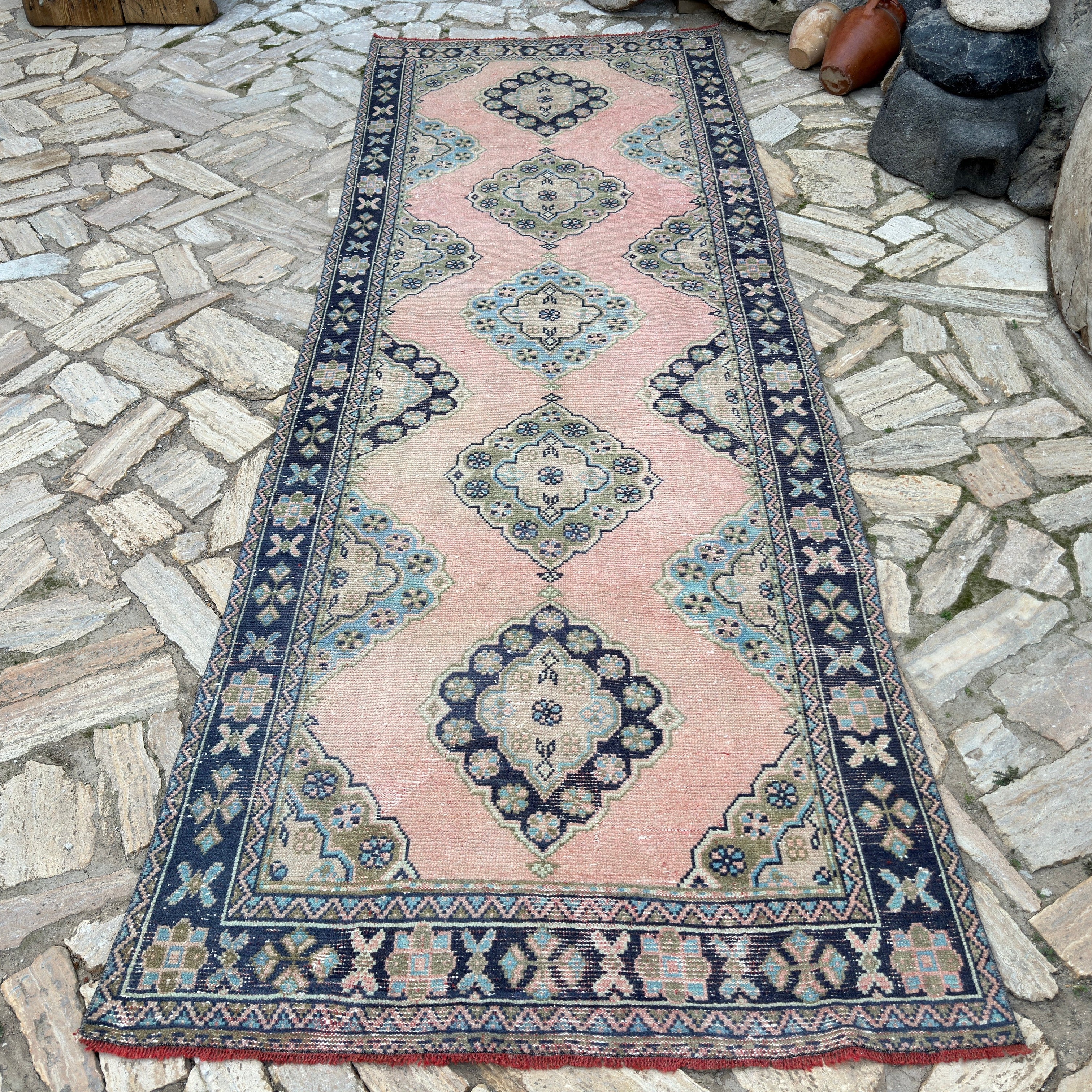 Pink 4' x 11' vintage turkish runner rug in wool and cotton, shown on the floor.