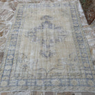 Close-up of the blue vintage Turkish wool distressed rug showing medallion details, hand-knotted weave, wool and cotton and low pile.