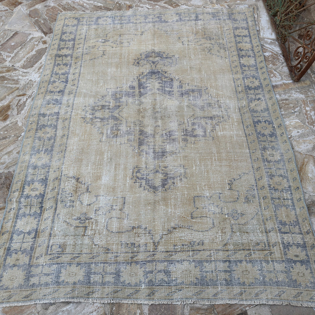 Close-up of the blue vintage Turkish wool distressed rug showing medallion details, hand-knotted weave, wool and cotton and low pile.