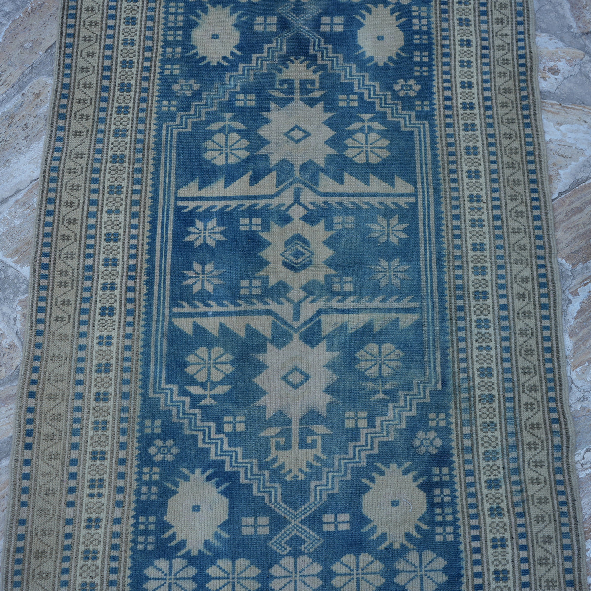 Close-up of the blue vintage Turkish wool rug showing neutral details, hand-knotted weave, wool and low pile.
