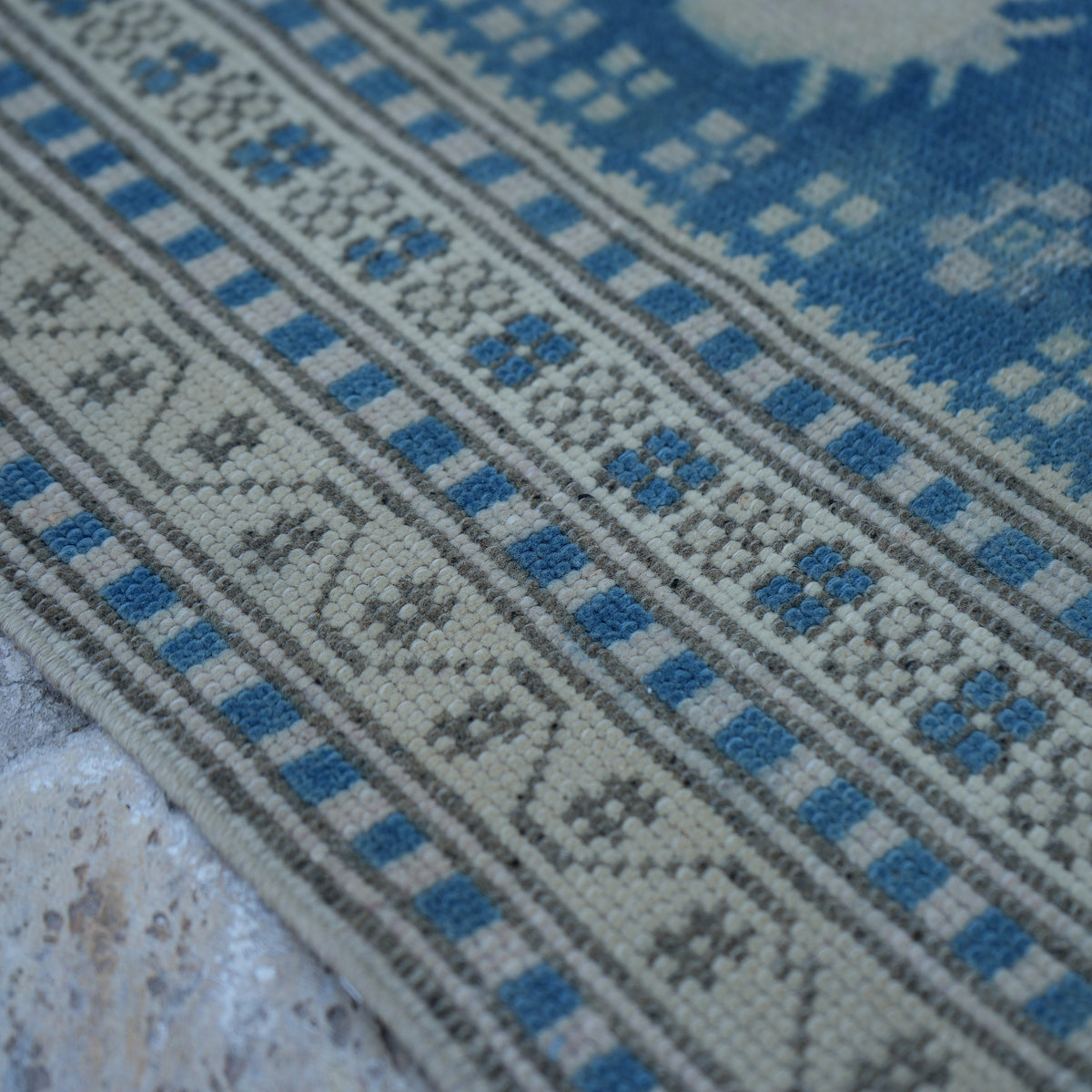 Blue 3' x 4' vintage Turkish wool rug in wool, shown on the floor.