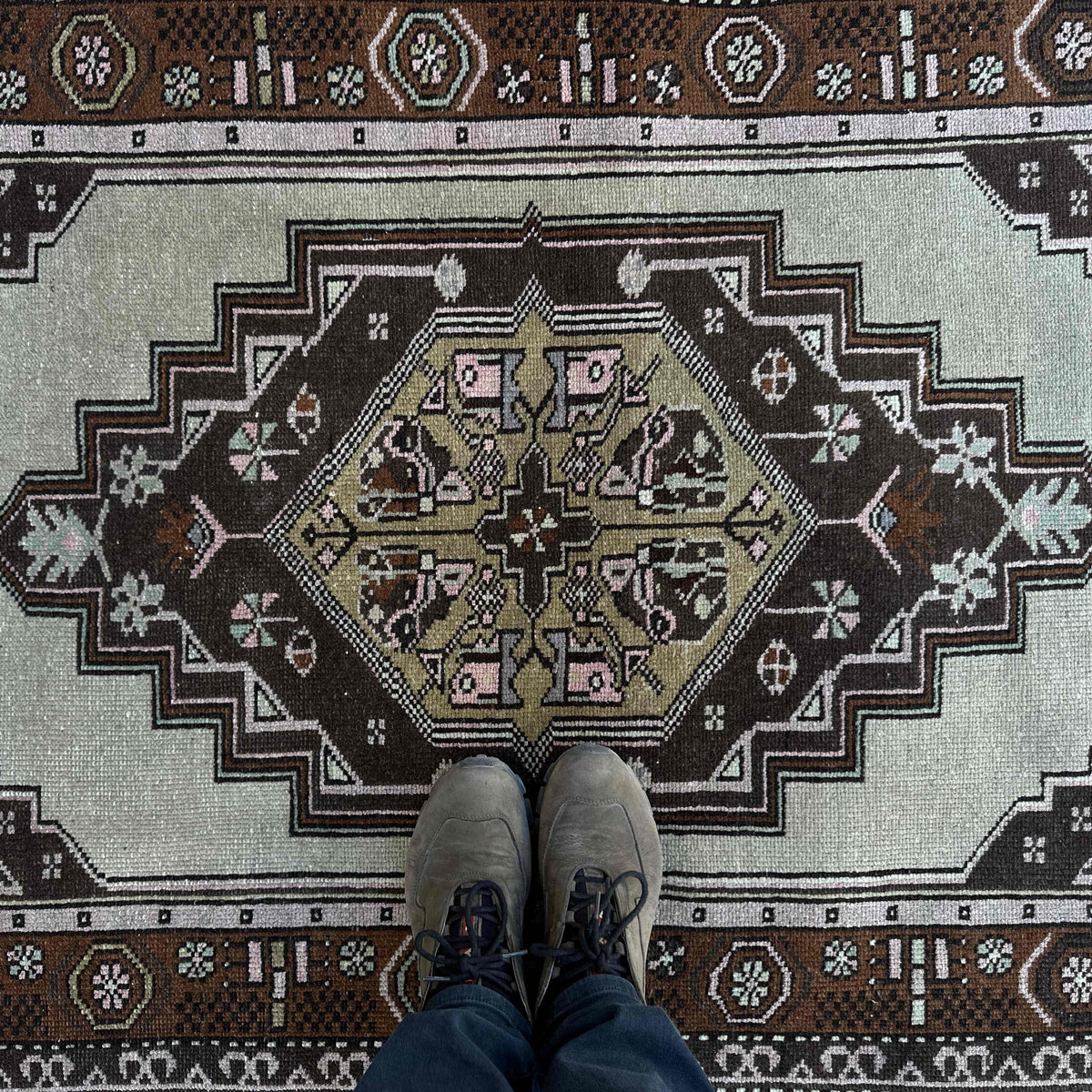 1970s brown vintage Turkish wool rug with traditional design, hand-knotted weave and low pile.