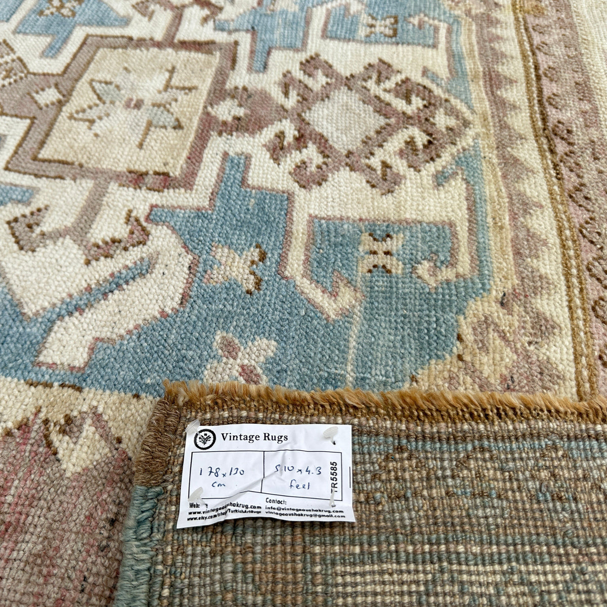 Close-up of the pale red vintage Turkish wool rug showing traditional details, hand-knotted weave, wool and cotton and low pile.