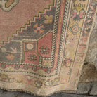 Close-up of the pink vintage Turkish wool rug showing neutral details, hand-knotted weave, wool and cotton and low pile.