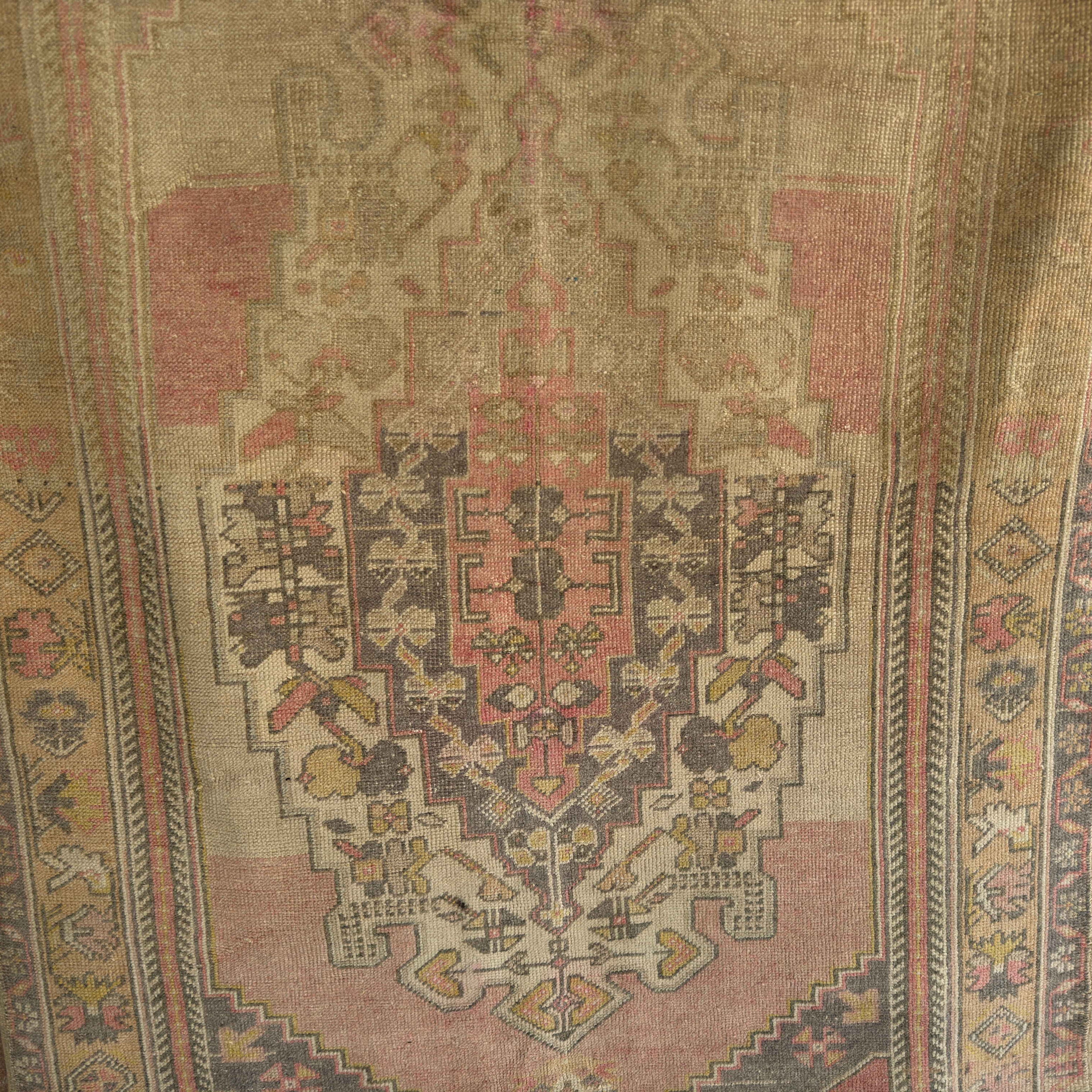 Pink 4' x 6' vintage Turkish wool rug in wool and cotton, shown on the floor.