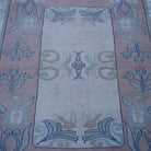 Close-up of the pink vintage Turkish wool rug showing geometric details, hand-knotted weave, wool and low pile.