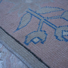 Pink 4' x 6' vintage Turkish wool rug in wool, shown on the floor.