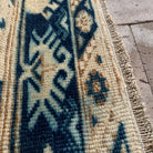 Close-up of the blue vintage Turkish wool rug showing neutral details, hand-knotted weave, wool and cotton and low pile.