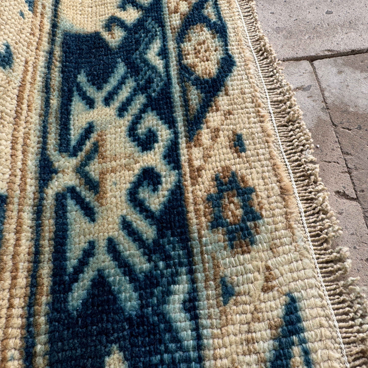 Close-up of the blue vintage Turkish wool rug showing neutral details, hand-knotted weave, wool and cotton and low pile.