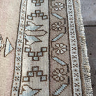 Close-up of the blue vintage Turkish wool rug showing neutral details, hand-knotted weave, wool and cotton and low pile.