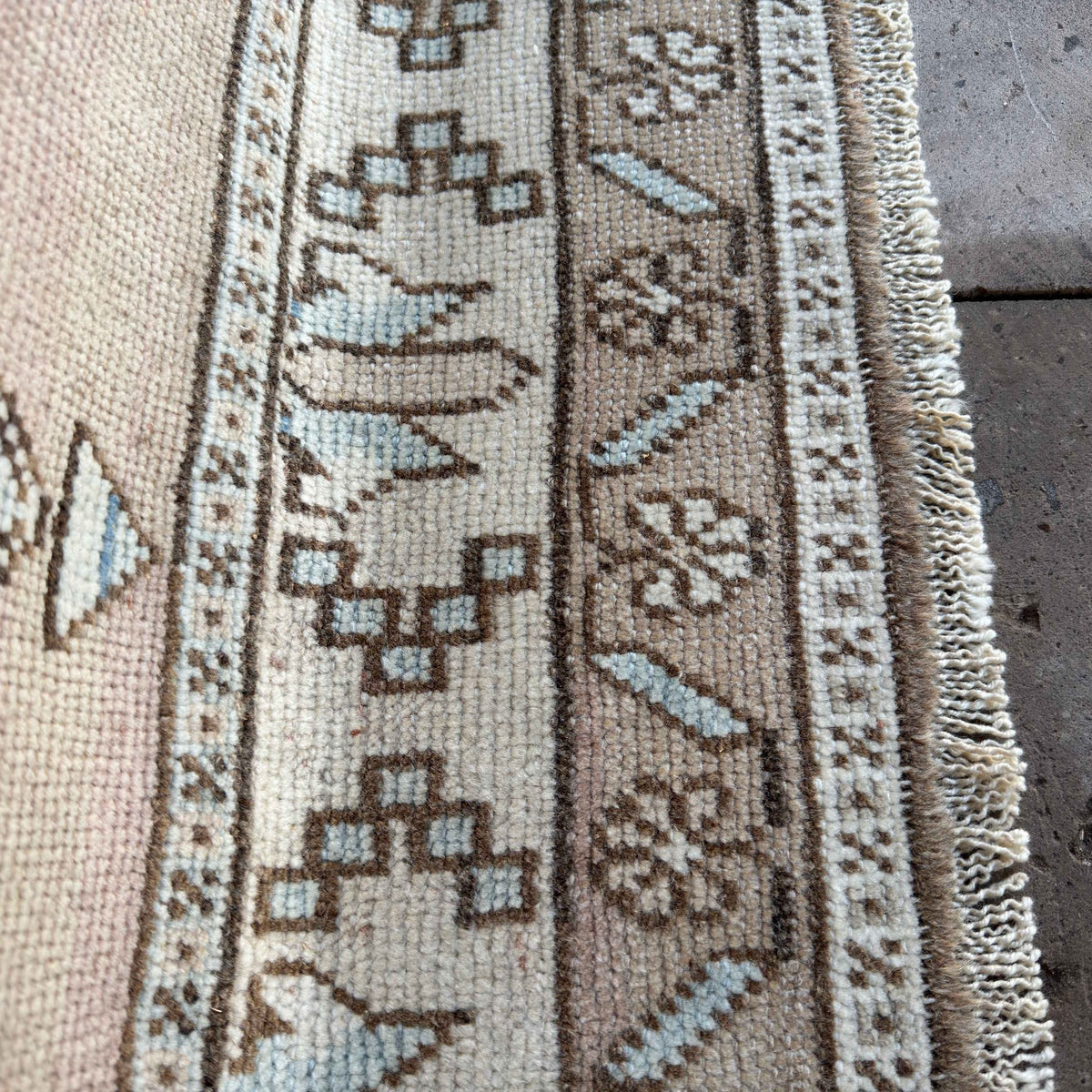 Close-up of the blue vintage Turkish wool rug showing neutral details, hand-knotted weave, wool and cotton and low pile.