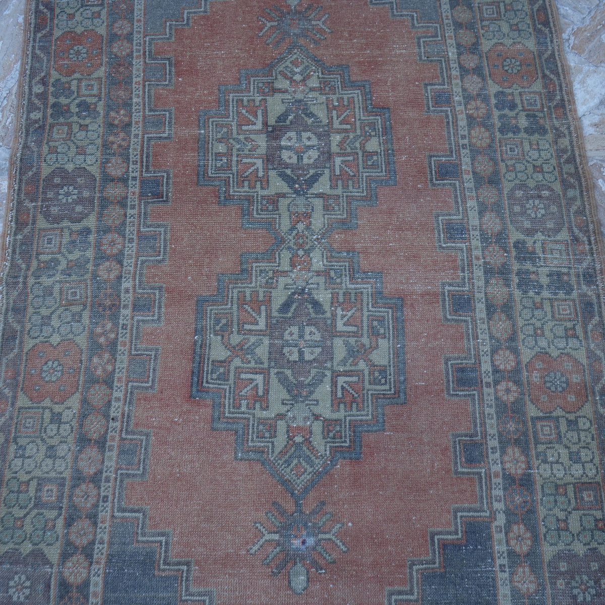 Close-up of the orange vintage Turkish wool rug showing traditional details, hand-knotted weave, wool and low pile.