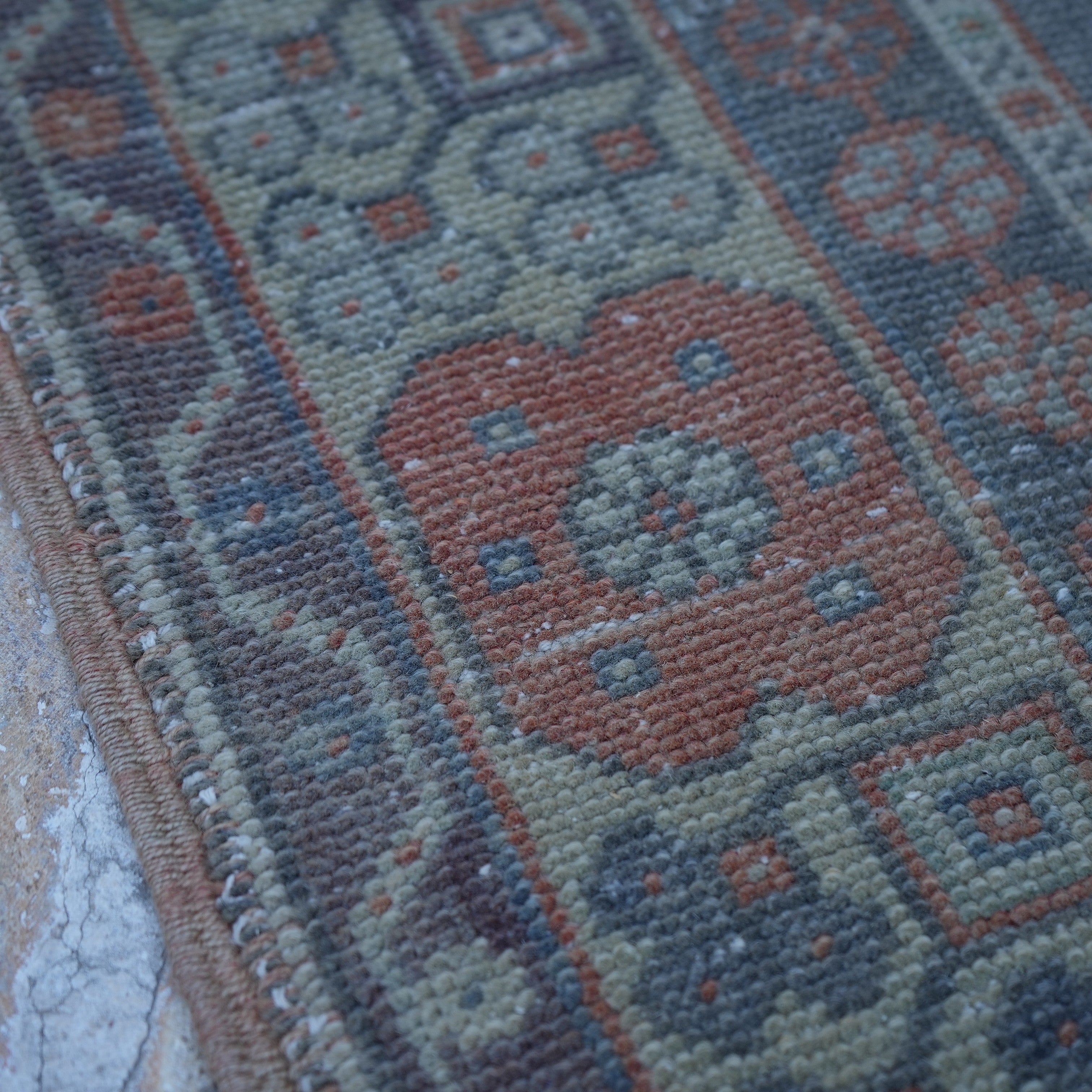 Orange 4' x 7' vintage Turkish wool rug in wool, shown on the floor.