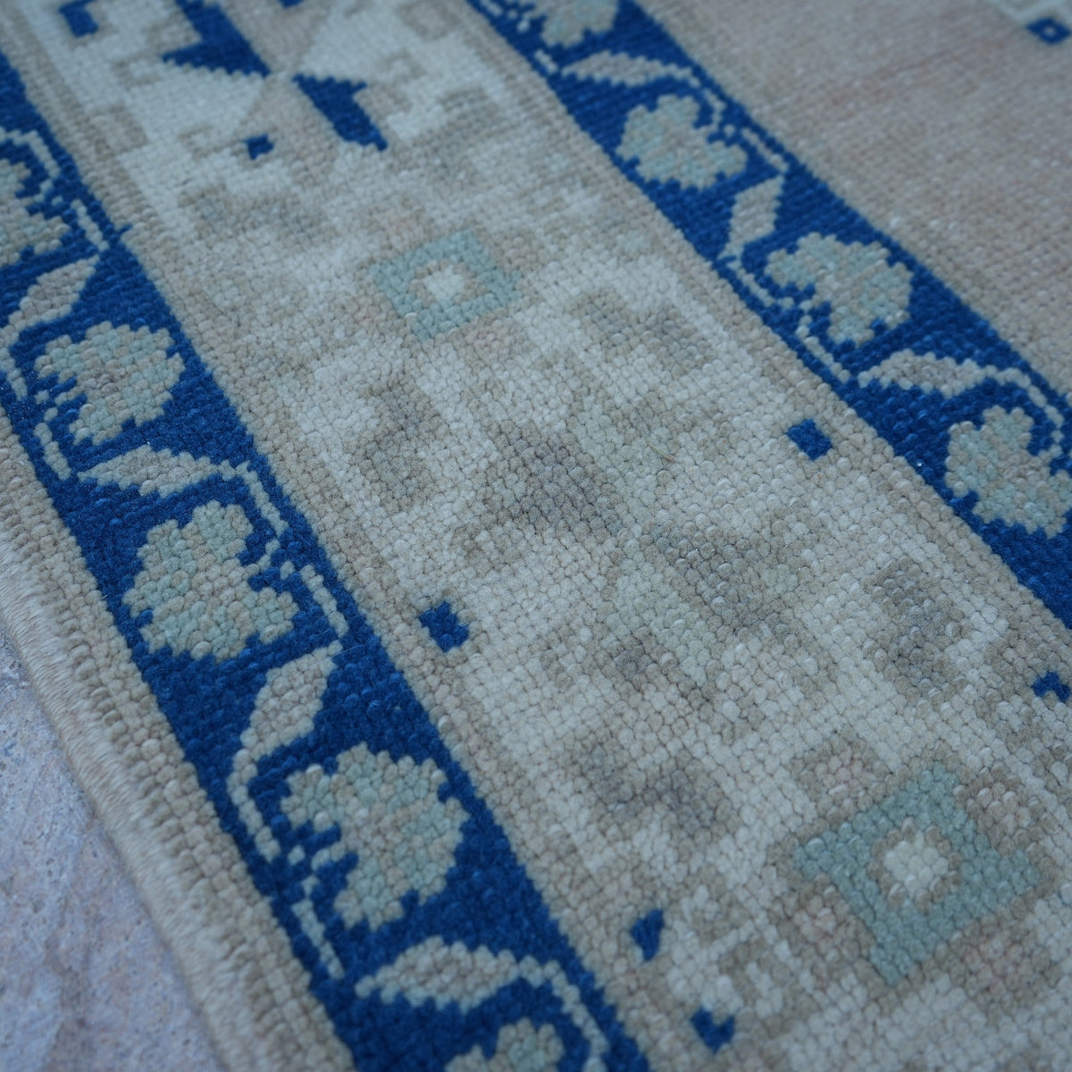 Blue 5' x 11' vintage Turkish wool rug in wool, shown on the floor.