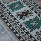 Beige 5' x 7' vintage Turkish wool rug in wool, shown on the floor.