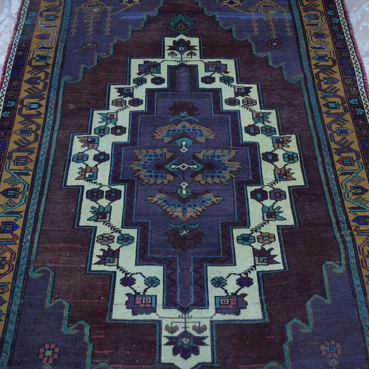 Close-up of the purple vintage Turkish wool rug showing traditional details, hand-knotted weave, wool and low pile.