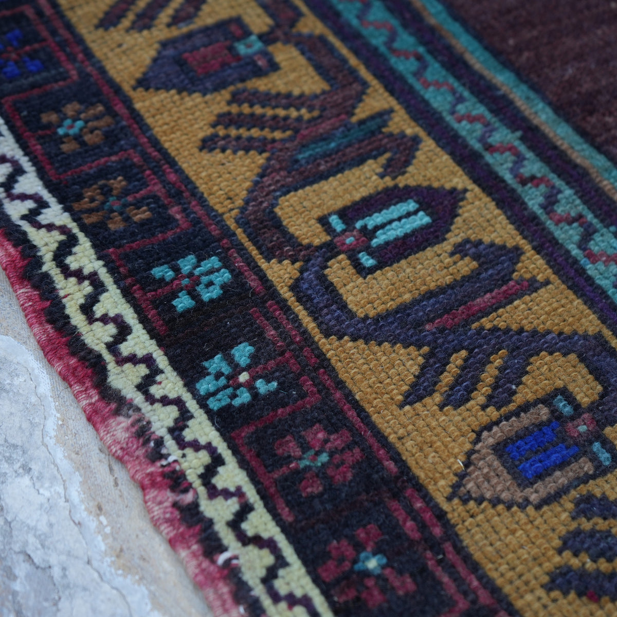 Purple 5' x 9' vintage Turkish wool rug in wool, shown on the floor.
