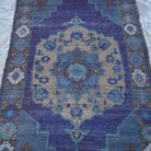 Close-up of the purple vintage Turkish wool rug showing traditional details, hand-knotted weave, wool and low pile.
