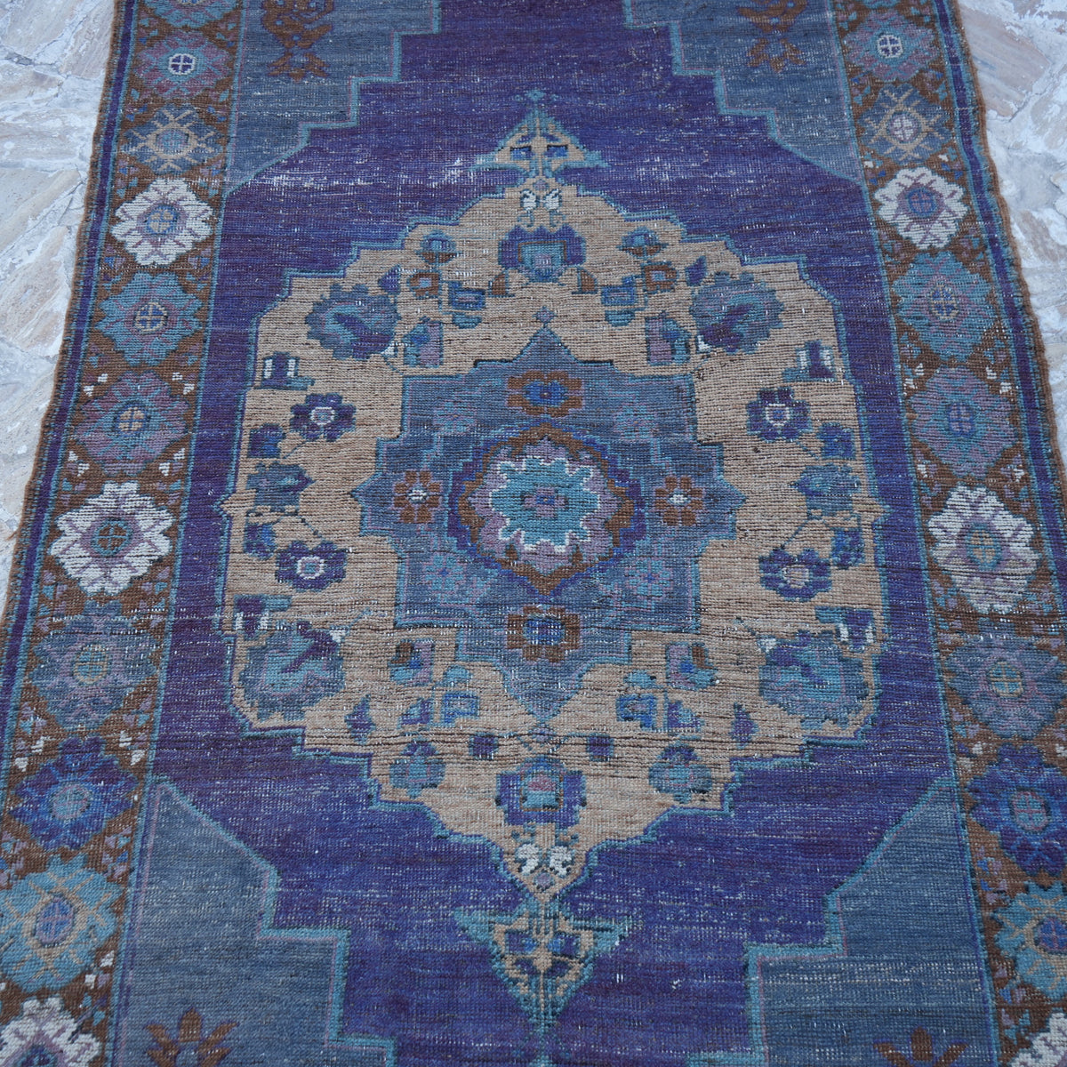 Close-up of the purple vintage Turkish wool rug showing traditional details, hand-knotted weave, wool and low pile.