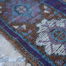 Purple 5' x 9' vintage Turkish wool rug in wool, shown on the floor.