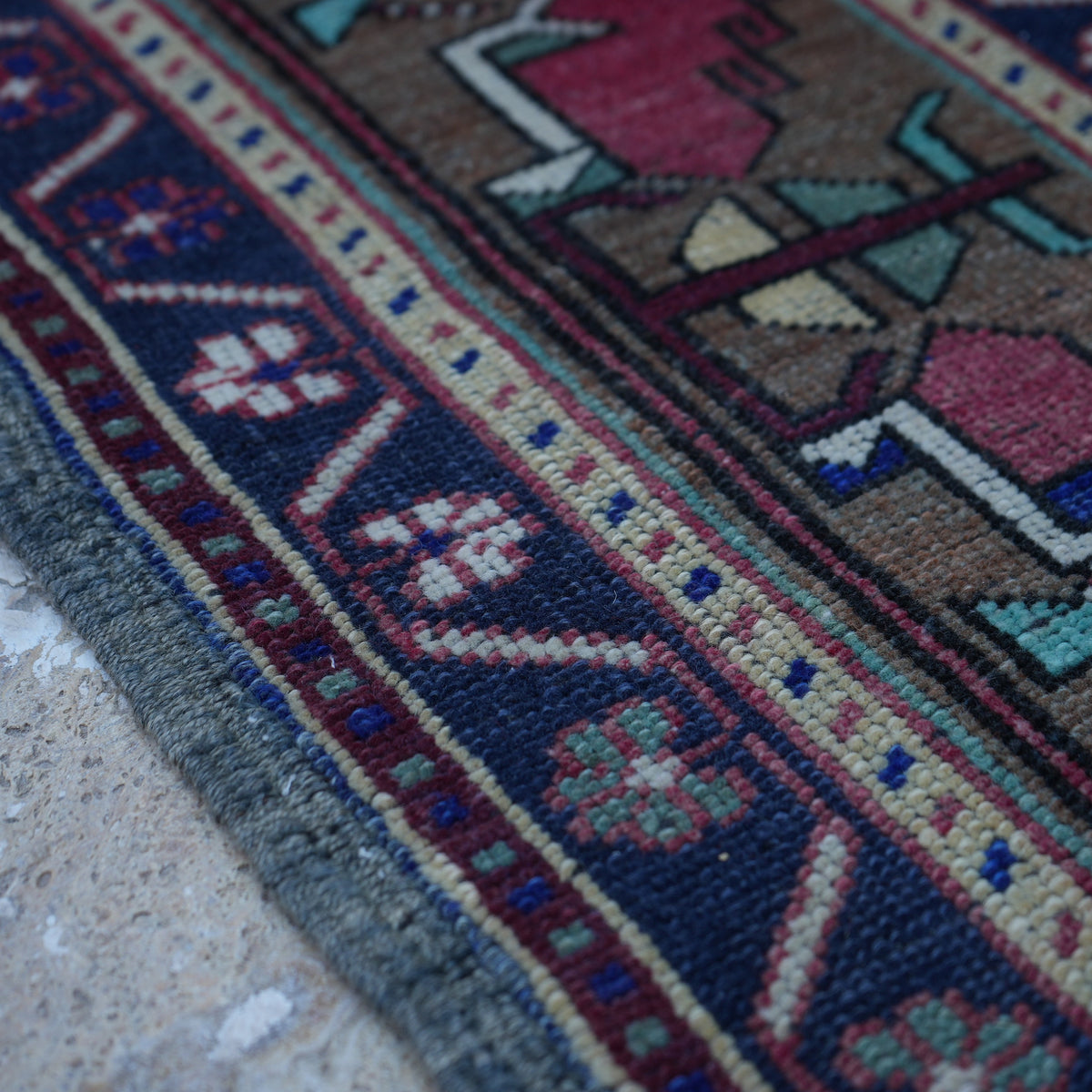 Red 5' x 9' vintage Turkish wool rug in wool, shown on the floor.