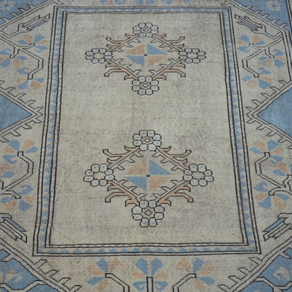 Close-up of the pale blue vintage Turkish wool rug showing geometric details, hand-knotted weave, wool and low pile.